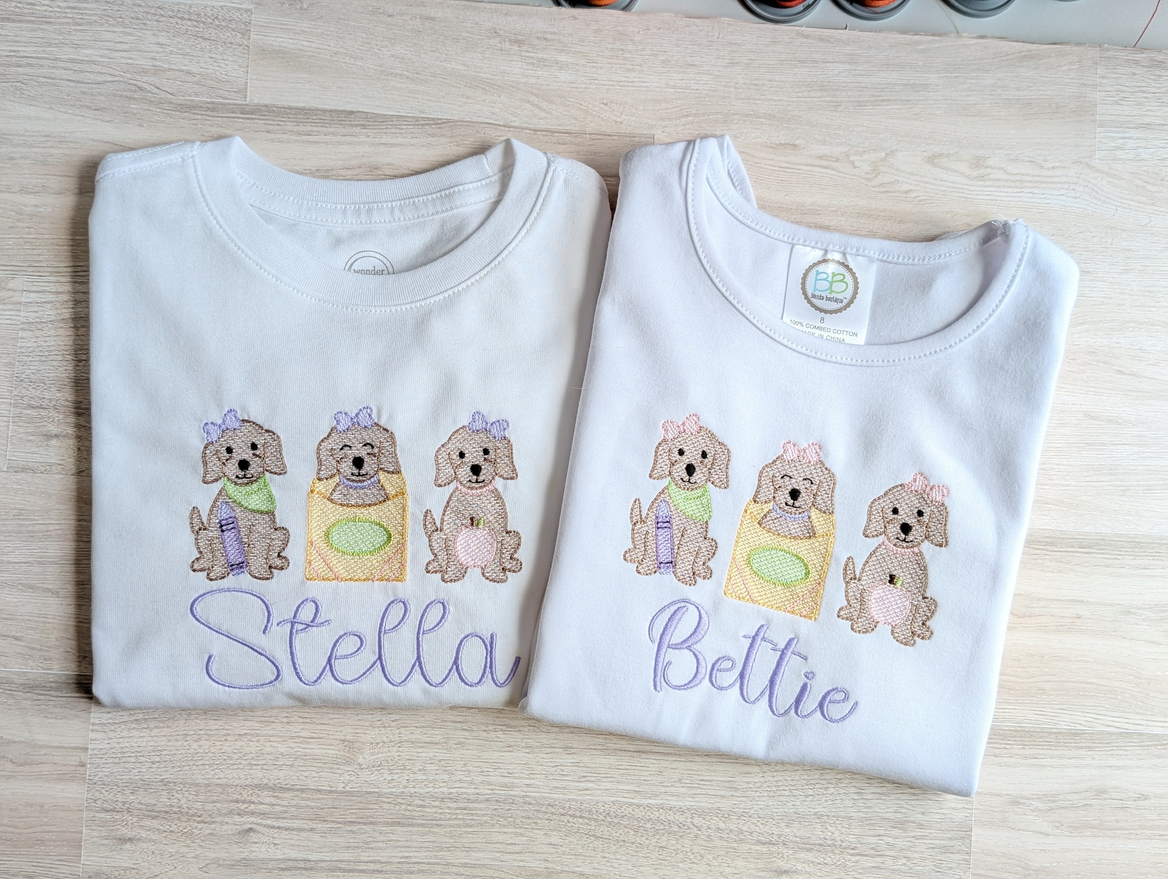Close-up of puppy trio embroidery with name Stella on classic tee