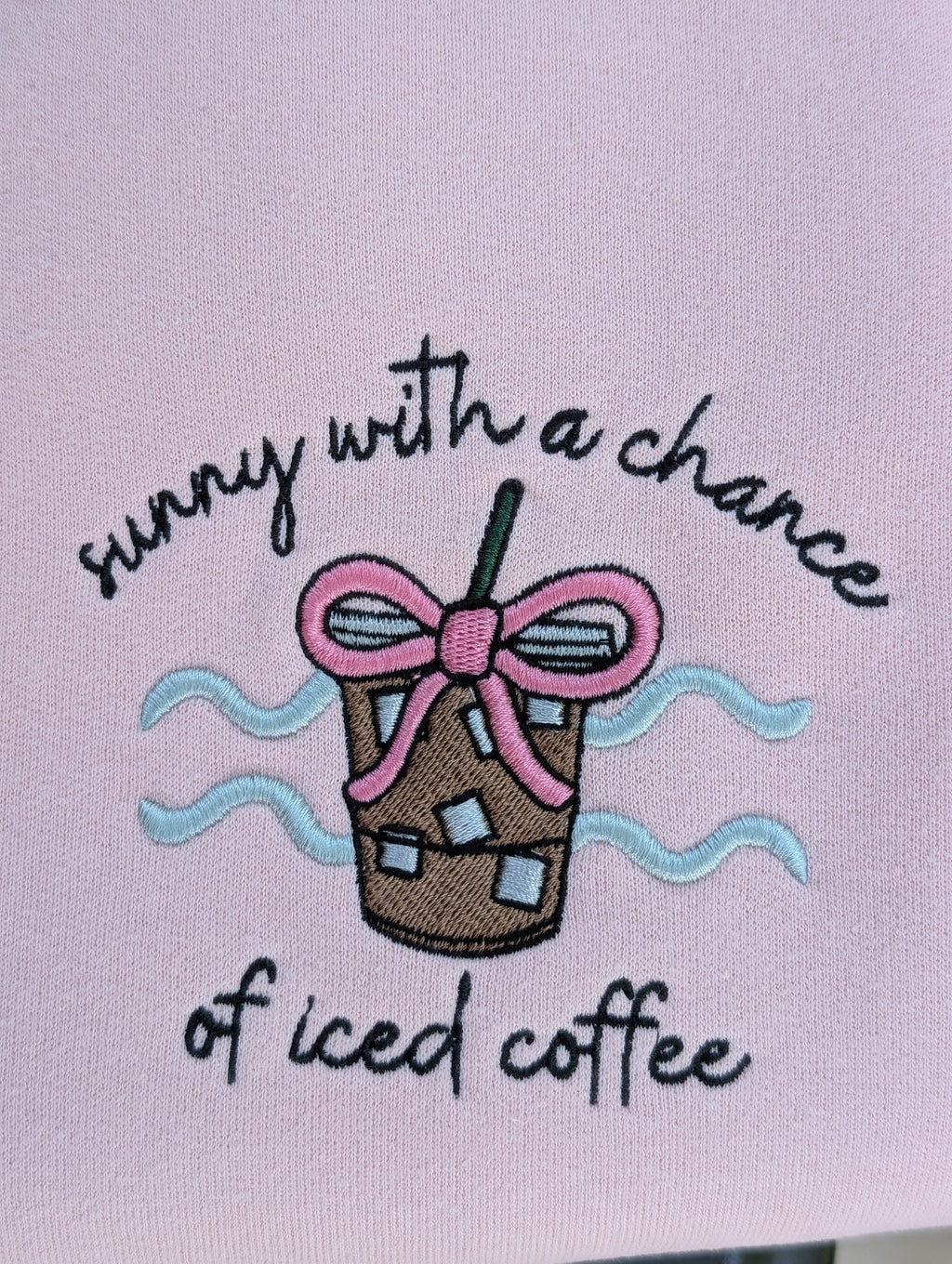 Close-up of iced coffee embroidery with pink bow detail