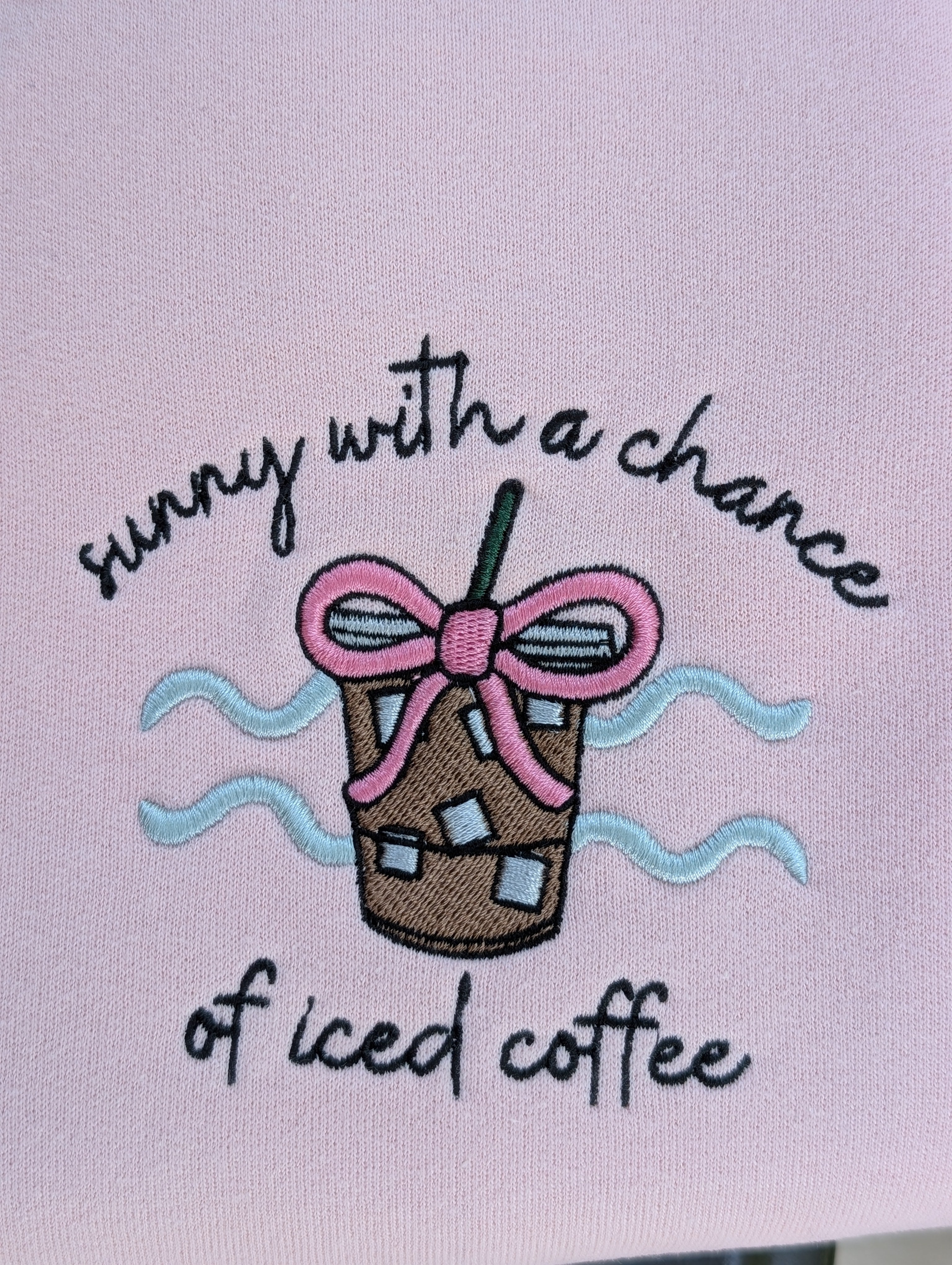 Close-up of iced coffee embroidery with pink bow detail