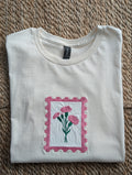 Comfort Colors cream women's tee with embroidered pink carnation postage stamp applique
