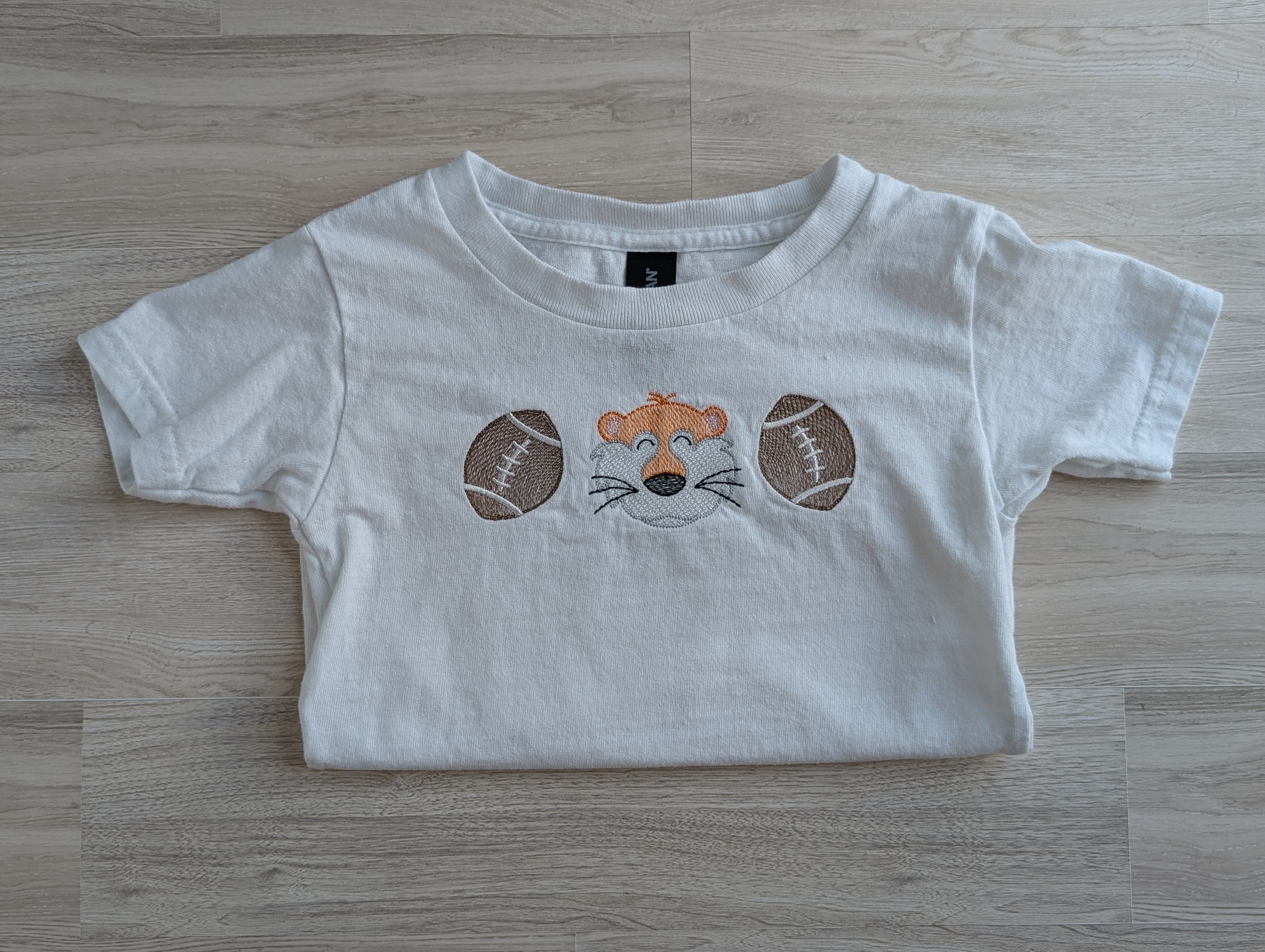 White premium cotton tee with embroidered tiger mascot and footballs design