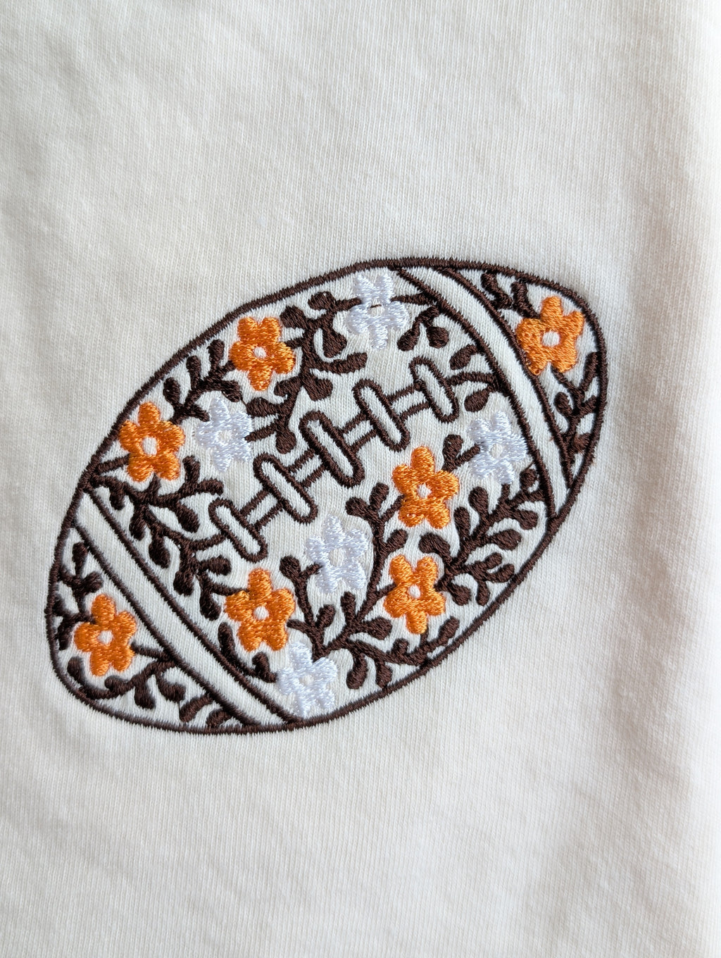 Floral football embroidered Comfort Colors tee, folded view