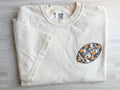 Close-up of floral football embroidery with orange flowers