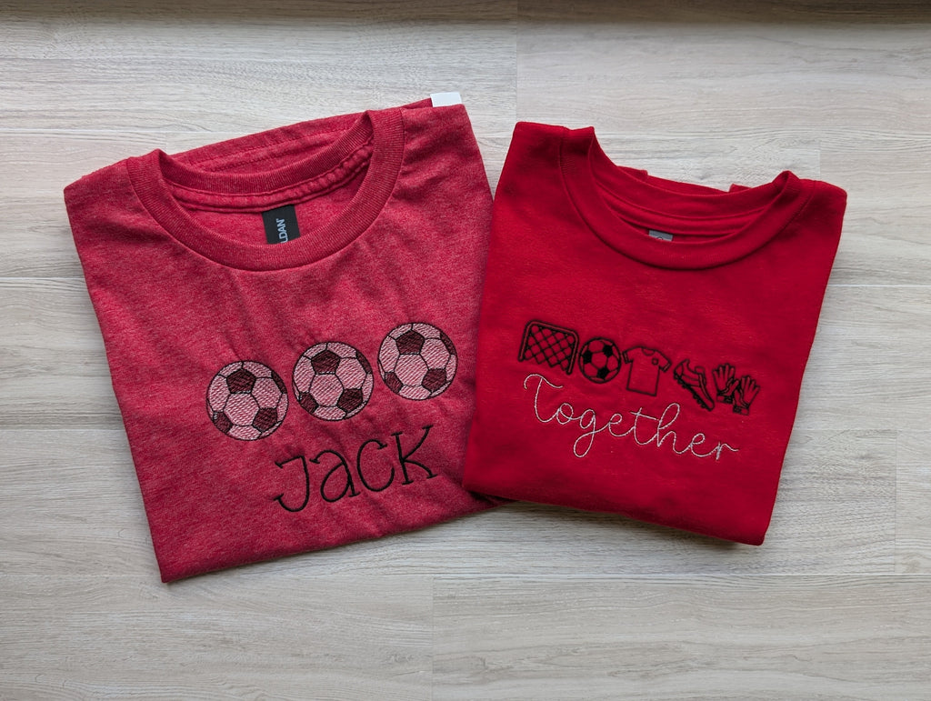 Two red soccer embroidered kids tees side by side showing personalized soccer ball trio design