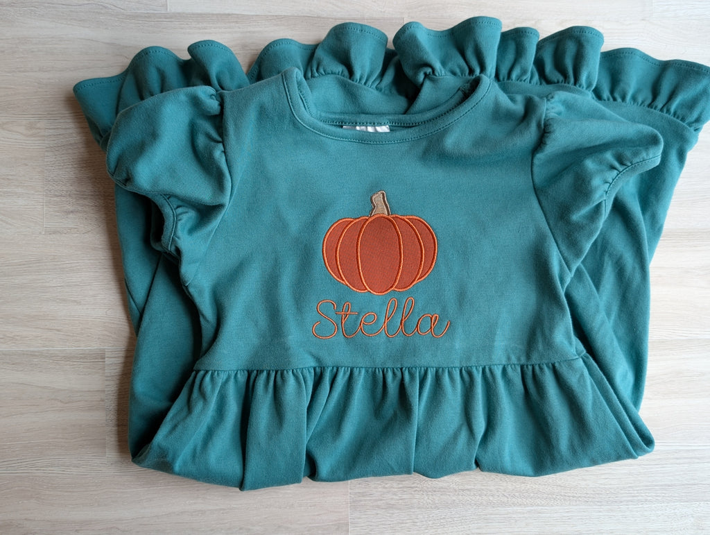 Personalized pumpkin ruffle dress in teal on hanger