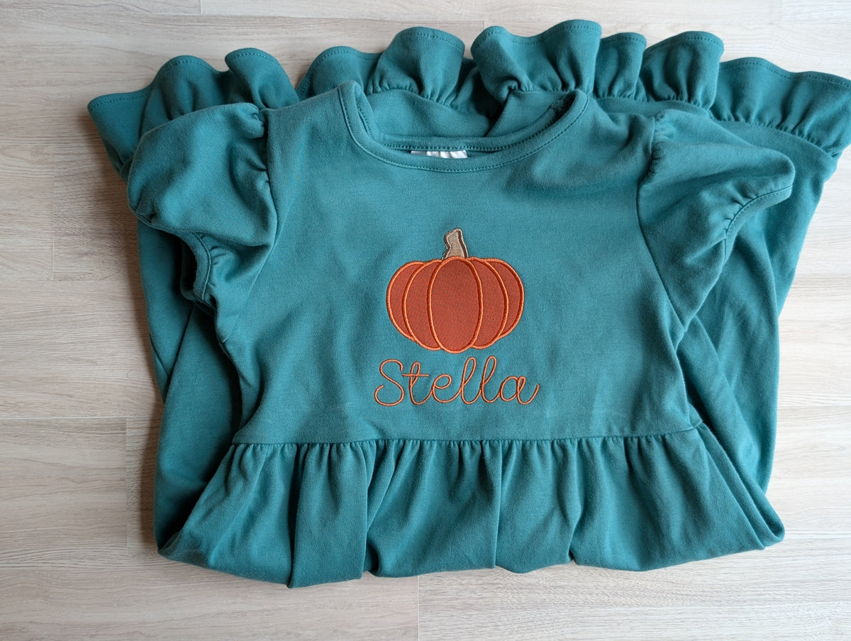 Personalized pumpkin ruffle dress in teal on hanger