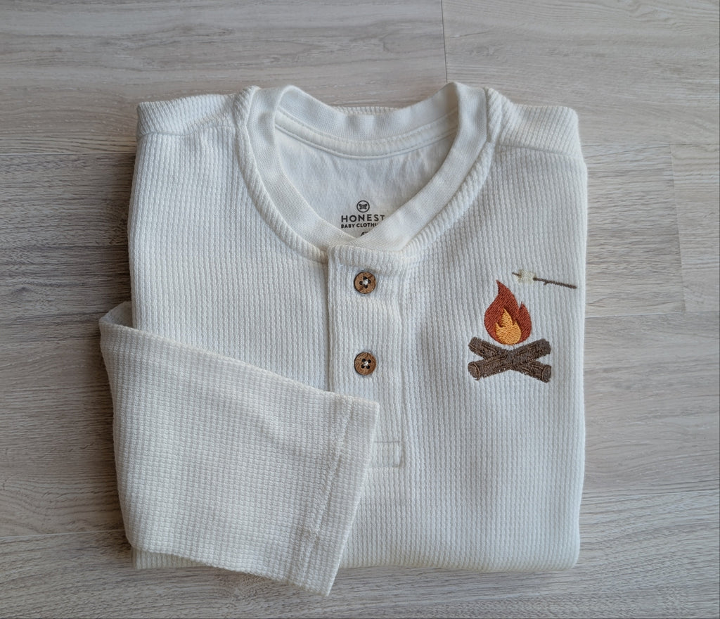 White waffle-knit long-sleeve henley with wood buttons and campfire and marshmallow design