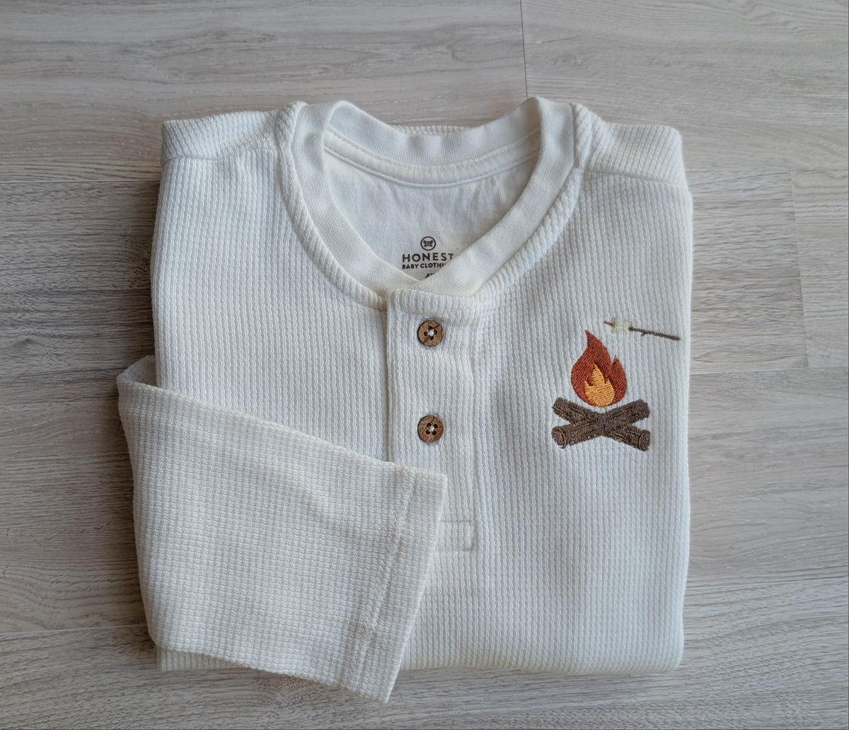 White waffle-knit long-sleeve henley with wood buttons and campfire and marshmallow design