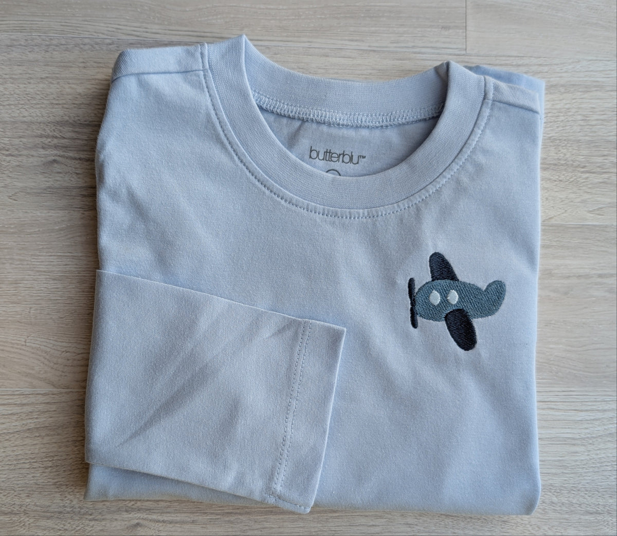 Light blue long-sleeve shirt with airplane embroidery on the chest