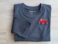 Navy blue size 5T long-sleeve shirt with red firetruck embroidery on the chest